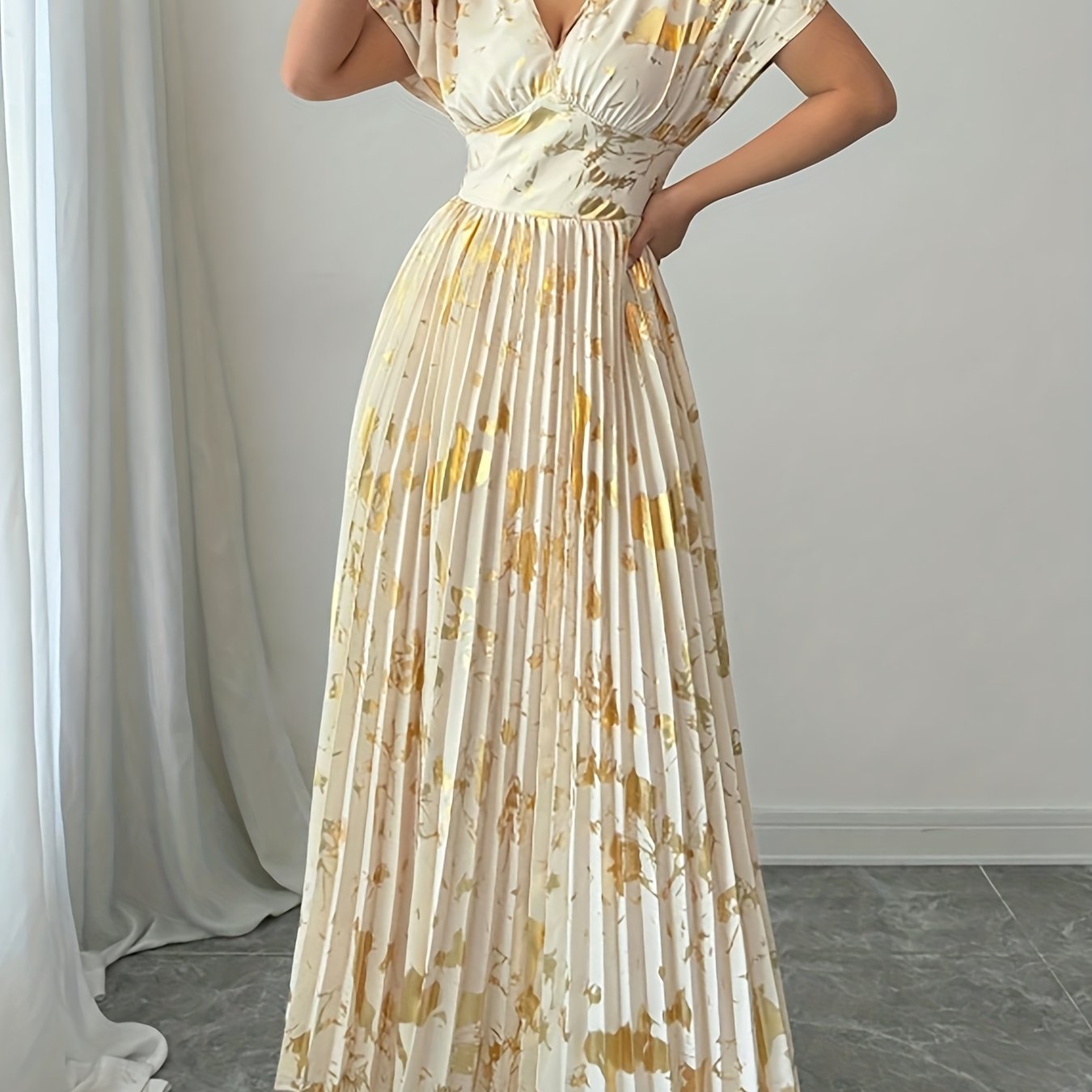 A Long Dress in Champagne Color, Featuring an Elegant And Refined Deep V-Neck, Drop Shoulders, a Cinched Waist, And Pleated A-Line Hem, Made from Gold-Printed Fabric, Perfect for Dates, Parties, And Everyday Fashion - SalmanStore 