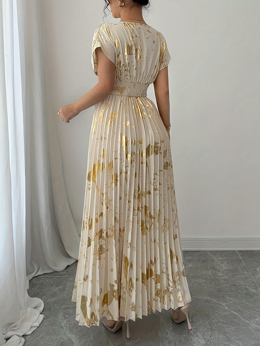 A Long Dress in Champagne Color, Featuring an Elegant And Refined Deep V-Neck, Drop Shoulders, a Cinched Waist, And Pleated A-Line Hem, Made from Gold-Printed Fabric, Perfect for Dates, Parties, And Everyday Fashion - SalmanStore 
