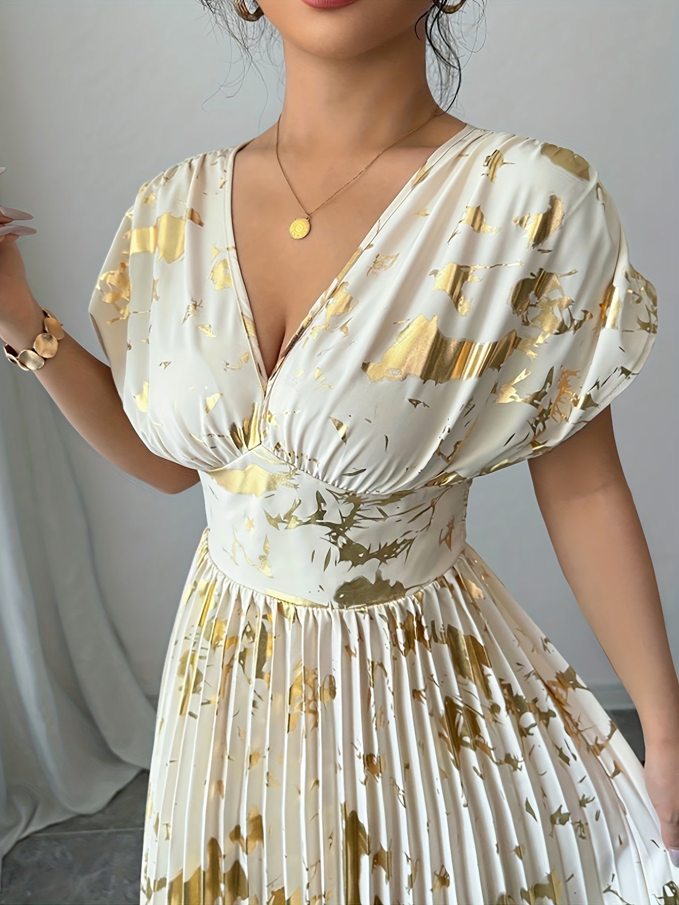 A Long Dress in Champagne Color, Featuring an Elegant And Refined Deep V-Neck, Drop Shoulders, a Cinched Waist, And Pleated A-Line Hem, Made from Gold-Printed Fabric, Perfect for Dates, Parties, And Everyday Fashion - SalmanStore 