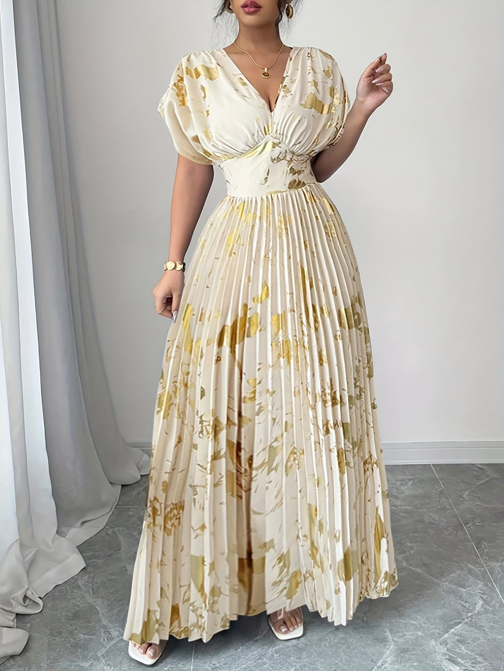 A Long Dress in Champagne Color, Featuring an Elegant And Refined Deep V-Neck, Drop Shoulders, a Cinched Waist, And Pleated A-Line Hem, Made from Gold-Printed Fabric, Perfect for Dates, Parties, And Everyday Fashion - SalmanStore 