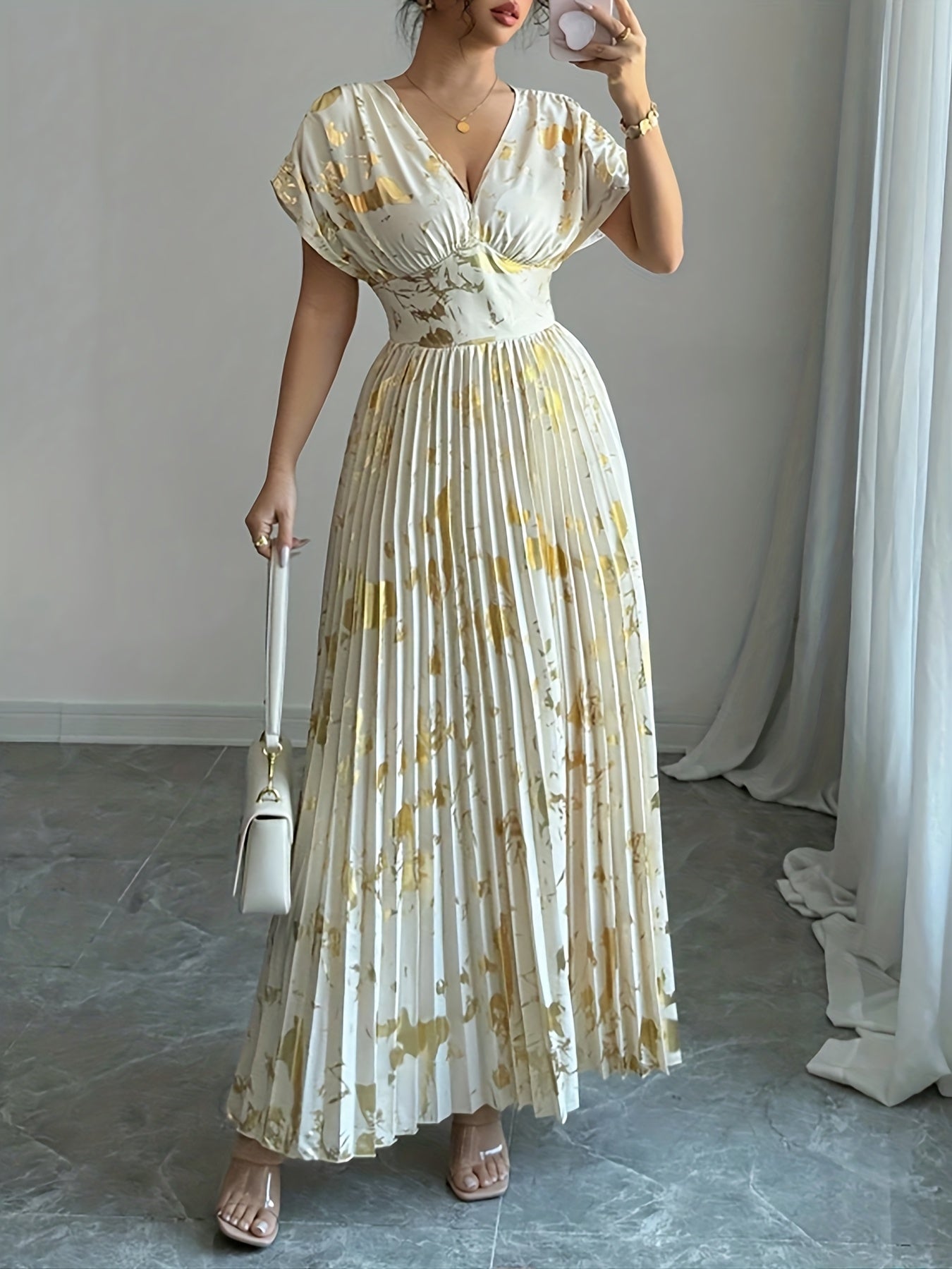 A Long Dress in Champagne Color, Featuring an Elegant And Refined Deep V-Neck, Drop Shoulders, a Cinched Waist, And Pleated A-Line Hem, Made from Gold-Printed Fabric, Perfect for Dates, Parties, And Everyday Fashion - SalmanStore 