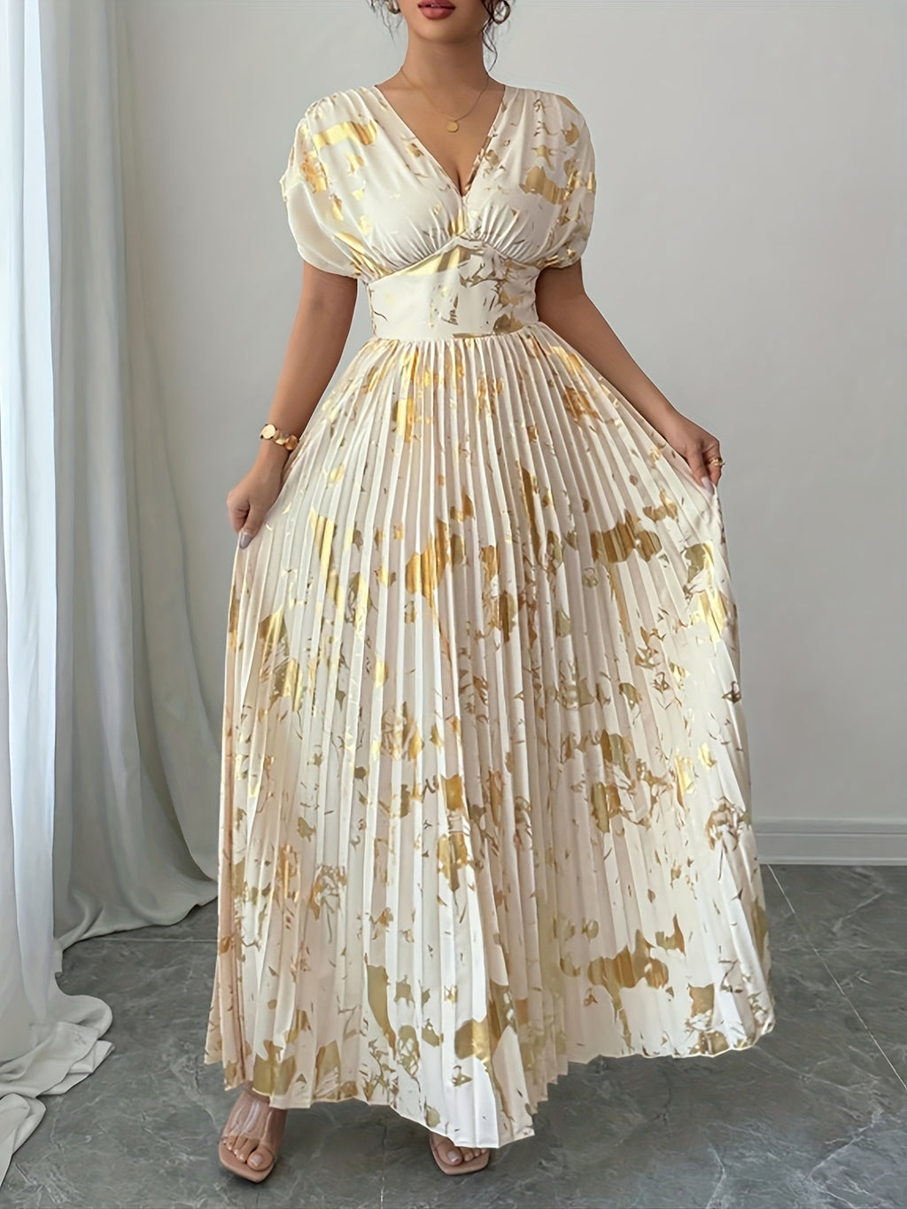 A Long Dress in Champagne Color, Featuring an Elegant And Refined Deep V-Neck, Drop Shoulders, a Cinched Waist, And Pleated A-Line Hem, Made from Gold-Printed Fabric, Perfect for Dates, Parties, And Everyday Fashion - SalmanStore 