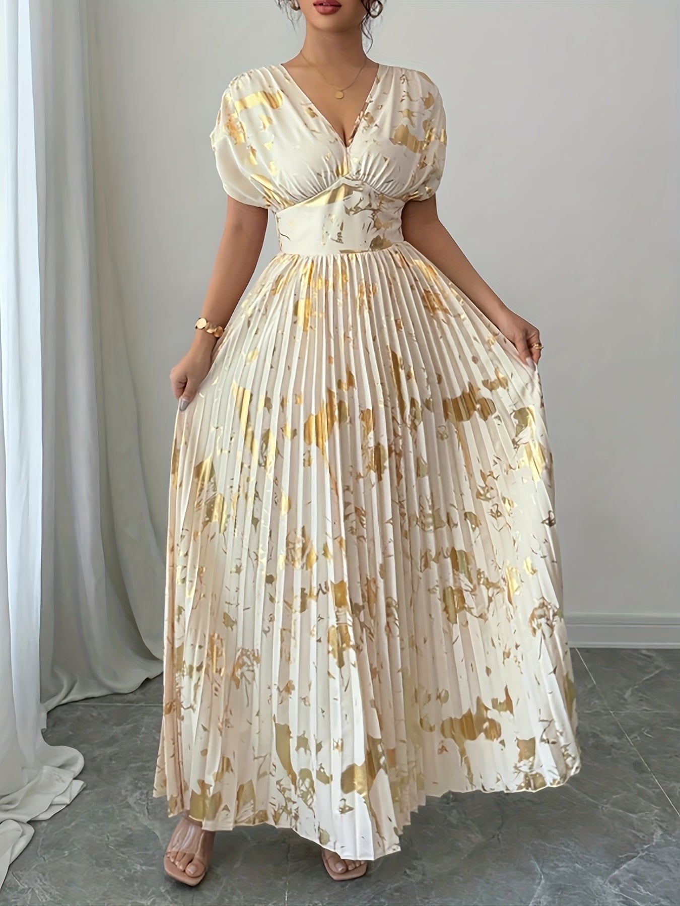 A Long Dress in Champagne Color, Featuring an Elegant And Refined Deep V-Neck, Drop Shoulders, a Cinched Waist, And Pleated A-Line Hem, Made from Gold-Printed Fabric, Perfect for Dates, Parties, And Everyday Fashion - SalmanStore 